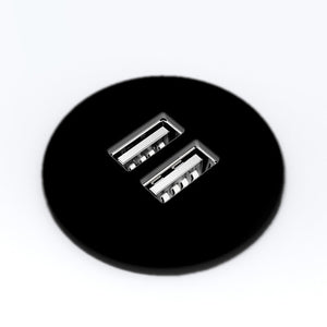 Round black two port USB charging module face seen from above