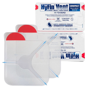 Two HyFin Vent chest seal packs printed compact and entry and exit wound, shown with the clear vented dressings in front