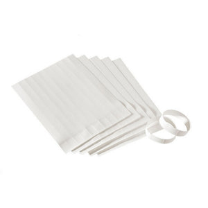 Stack of white Colop e-mark wristband sheets fanned out, with two bands torn off and closed into loops beside them
