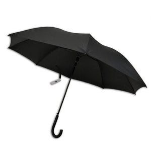 Standard black Compass umbrella open at an angle, showing the canopy, slim shaft, black crook handle and a white swing tag