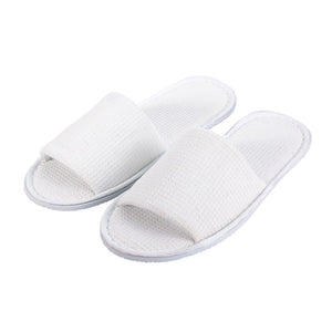 Pair of Compass white waffle open toe hotel slippers side by side, square waffle texture on the strap and footbed