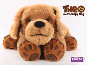 Theo the weighted therapy dog, a soft cream and brown plush dog lying flat with head resting forward, shown on a plain background.