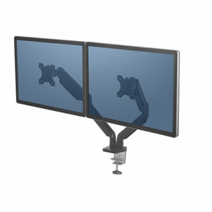Fellowes Platinum Series Dual Monitor Arm holding two screens side by side, seen from the left with the desk clamp under the base