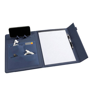 The navy blue Marbig 9000844 compendium open, with a phone upright in the fold out stand, earphones, cables and a card in the pouches, a lined pad and a pen in the loop