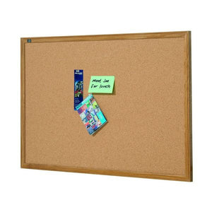 Quartet oak framed cork board shown landscape on white, with a green Meet Joe for lunch note, a slim brochure and a blue magazine pinned near the centre