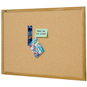 Oak framed Quartet cork board photographed landscape on white, a green Meet Joe for lunch note, a narrow brochure and a magazine pinned just left of centre