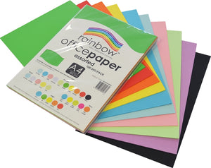 Clear poly wrapped pack of Rainbow Office Paper resting at an angle over a wide fan of about ten A4 sheets including green, red, orange, yellow, blue, pink, lilac and black, the label reading assorted, 100 sheets per pack.