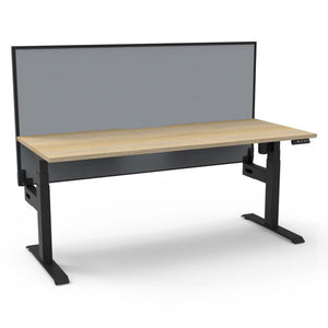 Rapidline Boost Light single sided electric sit-stand desk with a natural oak top on a black frame, a grey fabric screen across the back, with the controller at the front right edge