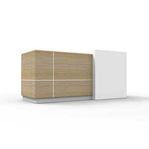 Rapidline Sempre reception counter in natural oak and white seen from the visitor side at an angle, natural oak panels beside a tall white stand off module.
