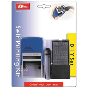 Shiny S-420 Self-Printing Kit D-I-Y Set on a blue and grey blister card, showing the blue self-inking printing stamp beside a sheet of rubber type and tweezers