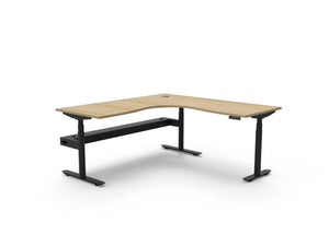 Rapidline Halo Plus electric height adjustable corner workstation on 70mm diameter round columns, E0 rated Natural Oak top with a black satin powdercoated frame, fitted ducted cable tray. Supplied product image for model H+CNRCT1P1818 NO/BL.