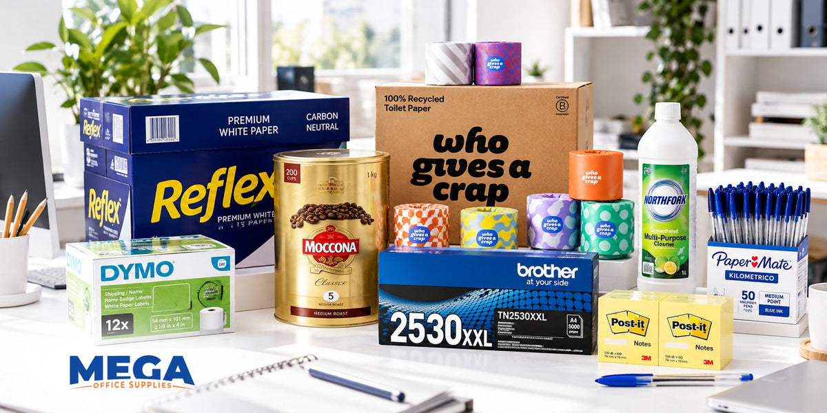 Mega Office Supplies workplace essentials displayed on a white office desk, featuring Reflex paper, Brother toner, DYMO labels, Moccona coffee, Who Gives A Crap toilet paper, Northfork cleaner, Paper Mate pens and Post-it notes.