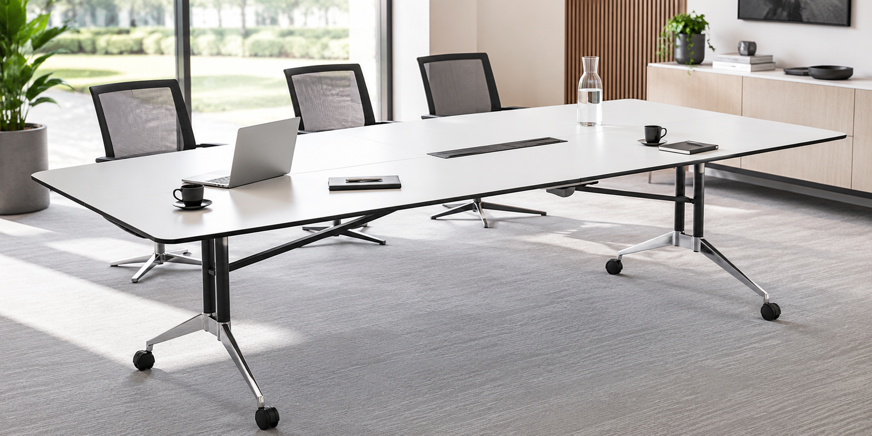 Modern office boardroom table with integrated power access in a bright professional meeting room.