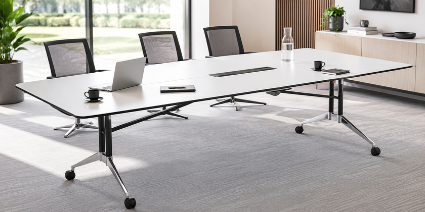 Modern office boardroom table with integrated power access in a bright professional meeting room.