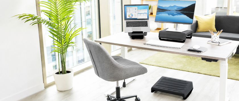 Bright modern technology workstation with laptop stand, monitor riser, keyboard, mouse and ergonomic footrest.