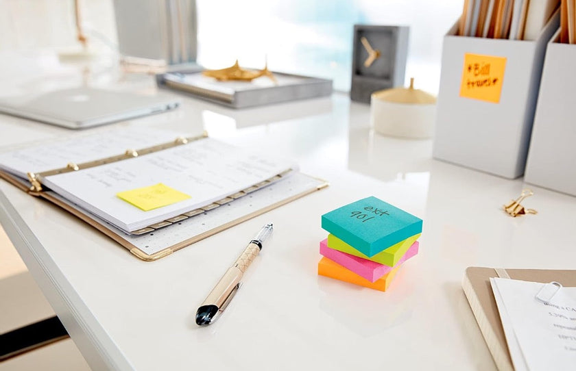 Colourful sticky note cube on a clean office desk with a planner, pen and filing organiser for quick reminders and daily task planning.