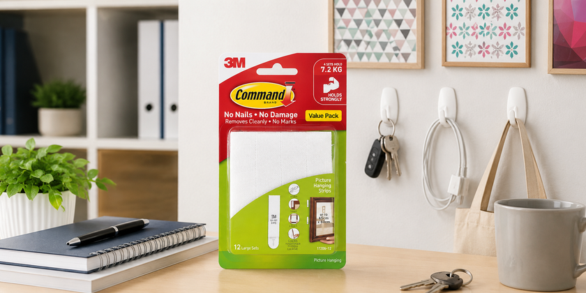 3M Command picture hanging strips displayed in a bright organised workspace with framed prints, wall hooks, keys and office stationery.