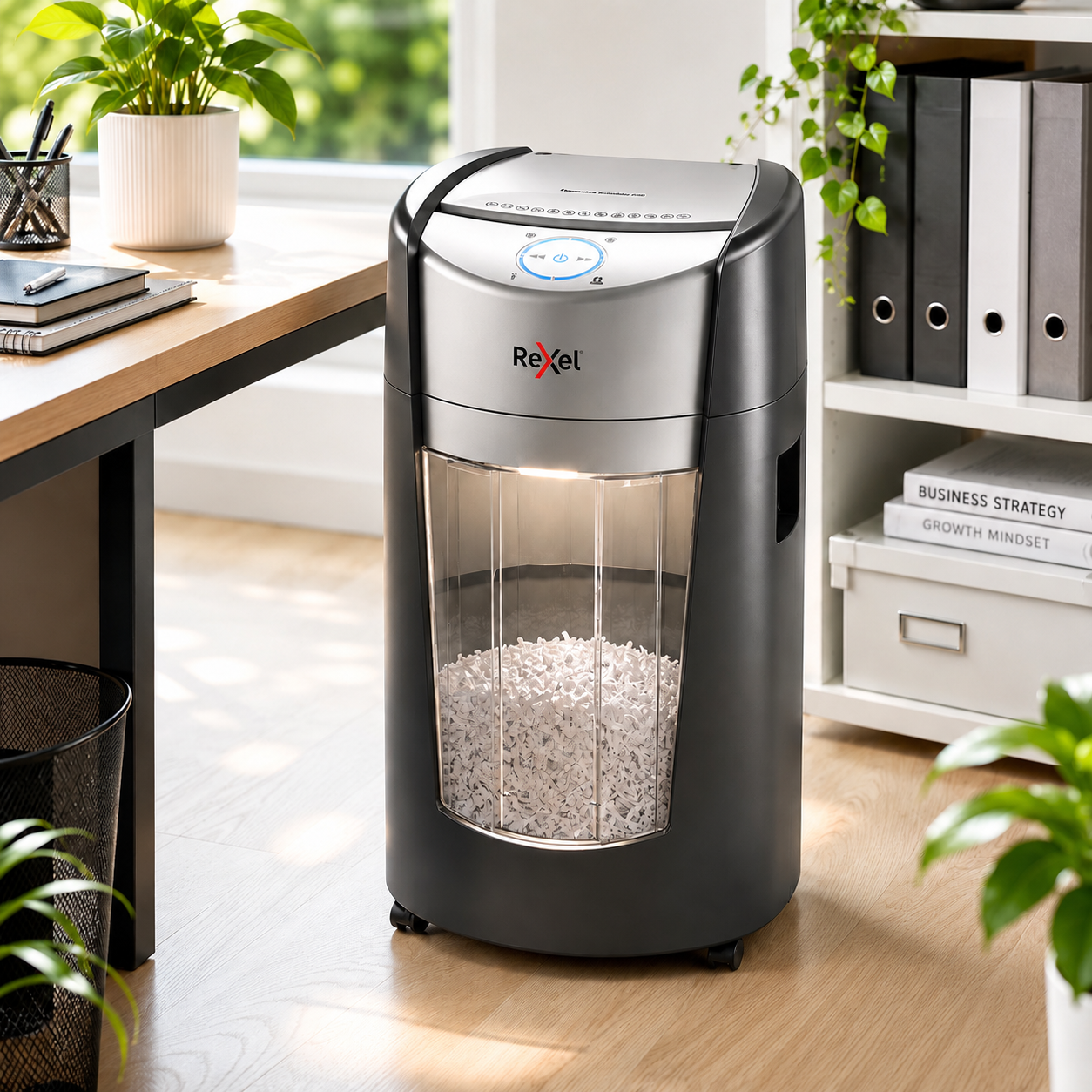 Office shredder in a bright modern workspace with shredded paper inside, plants, desk and tidy office storage.