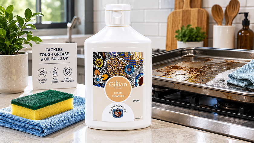 Fat and grease remover cleanser on a modern kitchen bench with a sponge, cloth and greasy oven tray nearby.