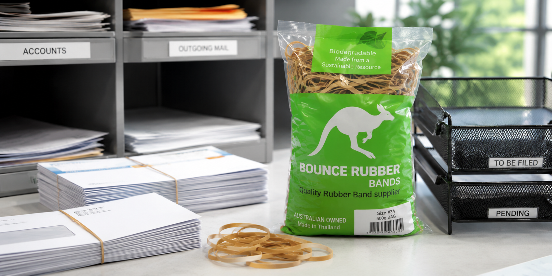 Rubber bands on a mailroom sorting bench with bundled envelopes and office trays.