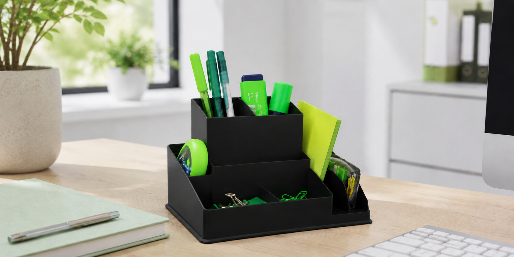 Desk organiser with pens, notes and stationery on a clean modern office desk for a tidy and productive workspace.