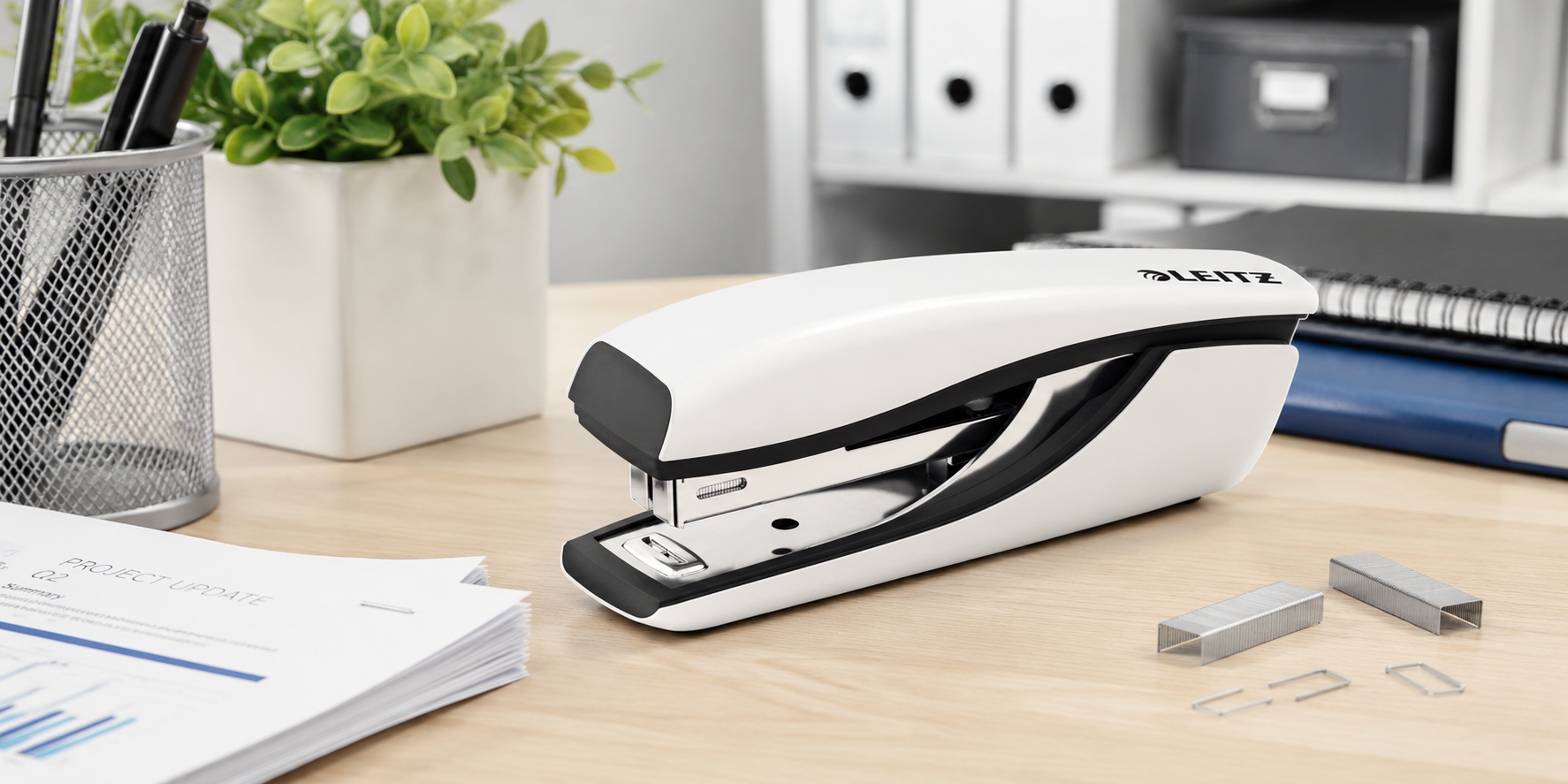 Modern white office stapler on a clean workstation for everyday document fastening in offices, schools and home workspaces.