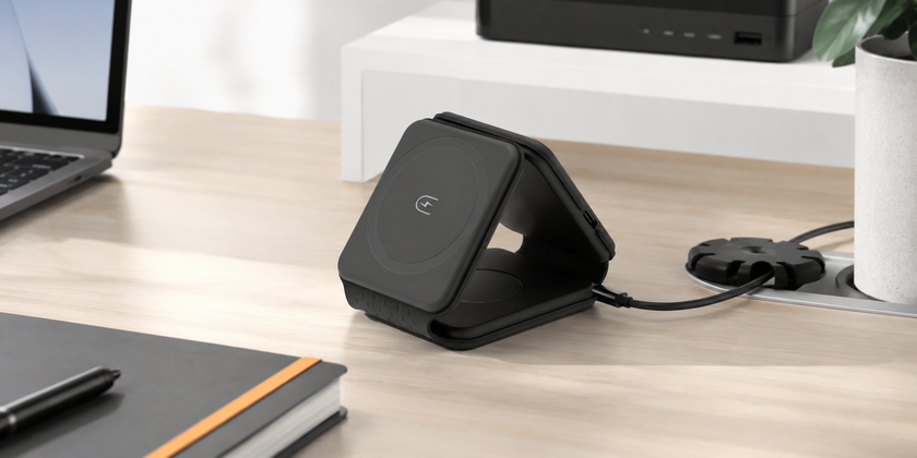 Office power supplies displayed on a modern workstation desk with a wireless charger, laptop, notebook and cable management accessories.