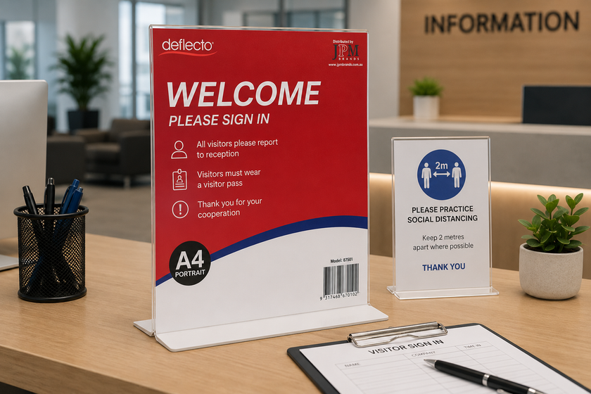Office sign holders arranged on a modern reception desk with visitor sign in notice, information display and workplace stationery.
