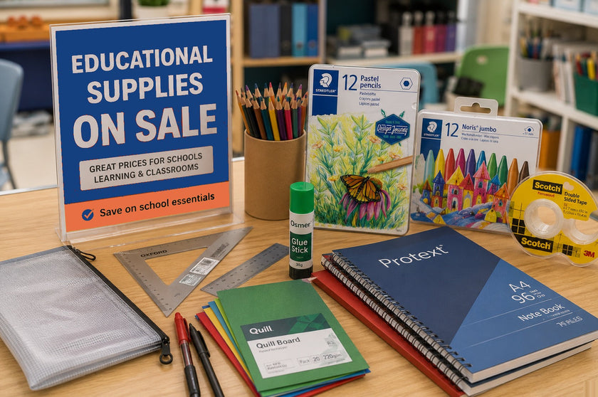 Educational supplies on sale displayed on a realistic classroom table with notebooks, glue, coloured pencils, rulers, craft board and stationery for school learning needs.