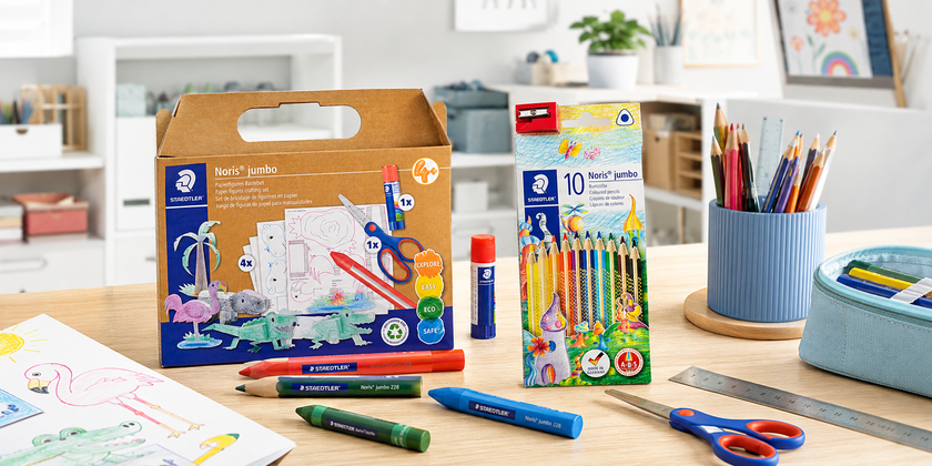 Bright classroom colouring table with coloured pencils, markers, sketchbook, pencil case and organised art supplies.