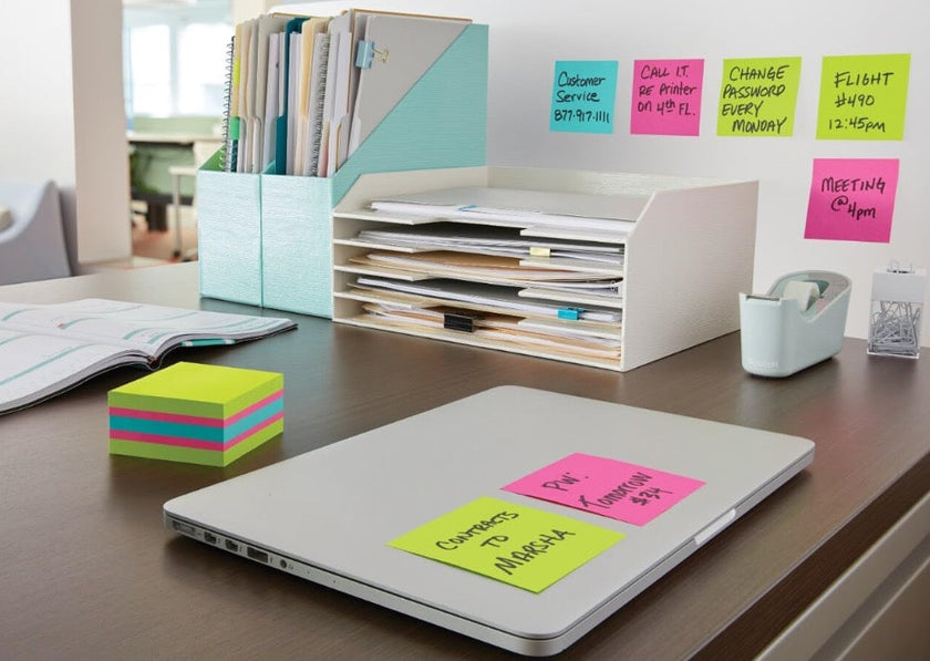 Sticky note cube on a bright office meeting table with colourful notes for high volume desk use.