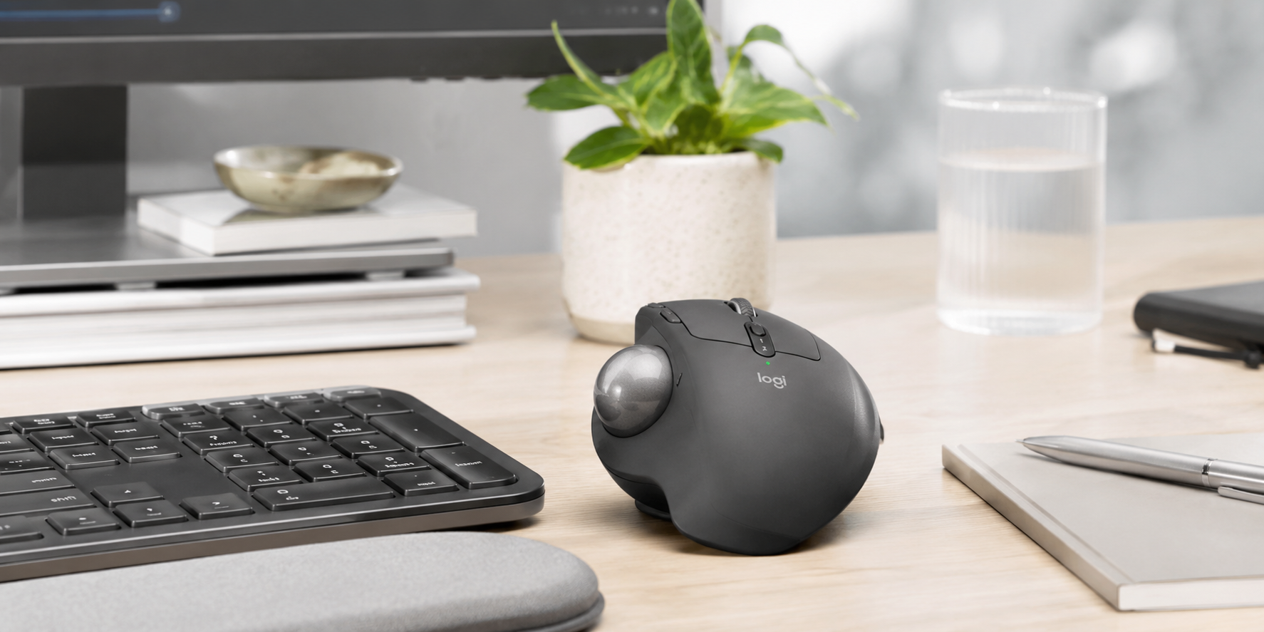 Ergonomic trackball mouse on a modern office desk with keyboard, monitor and workspace accessories.