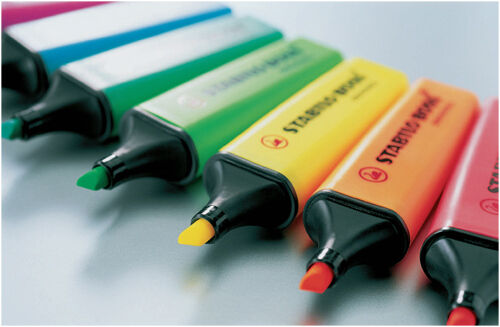 Set of colorful highlighters with visible brand name on a light background