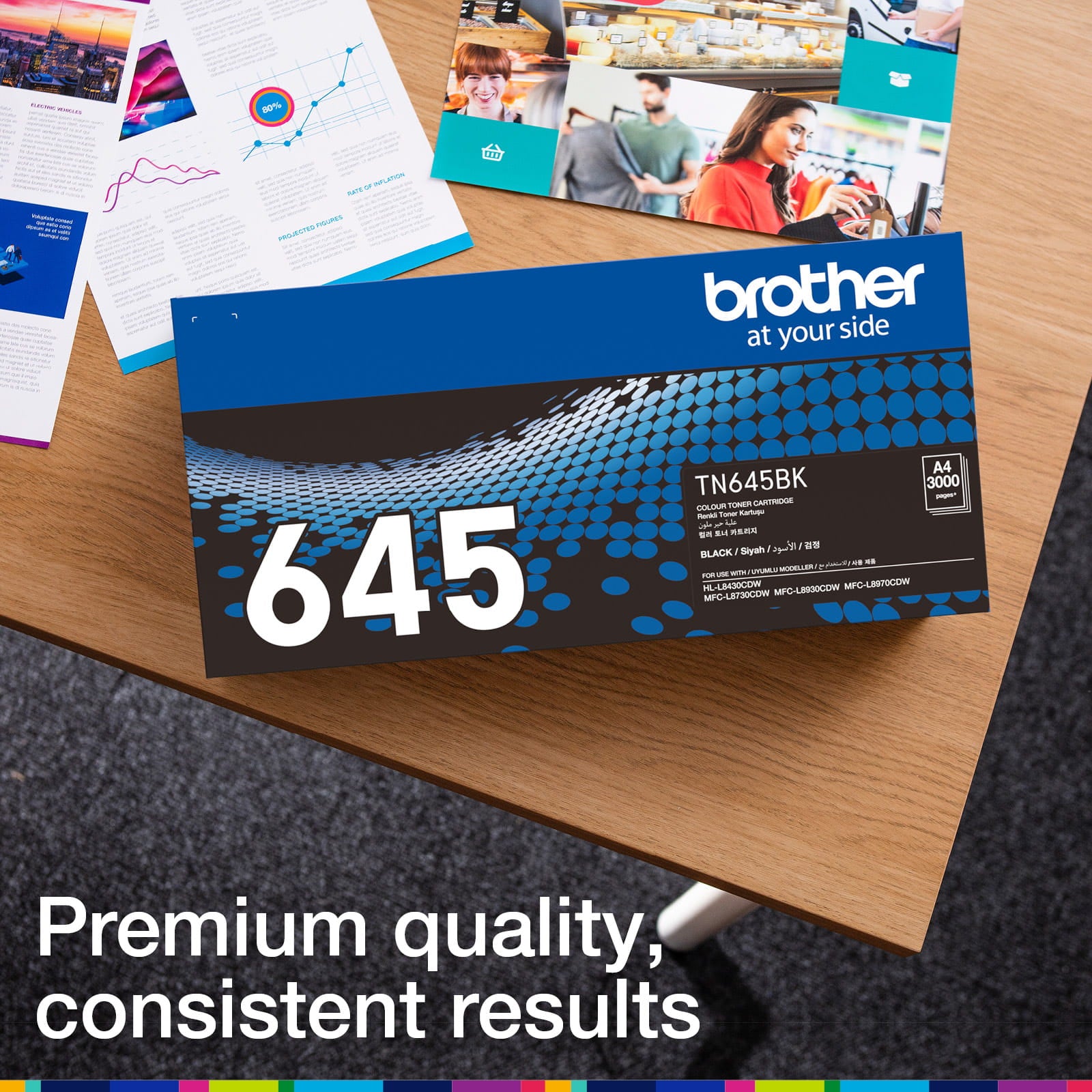 Brother TN-645BK retail carton photographed beside printed colour documents