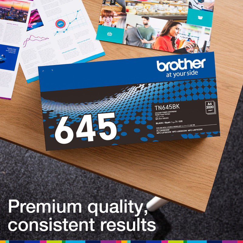 Brother TN-645BK retail carton photographed beside printed colour documents