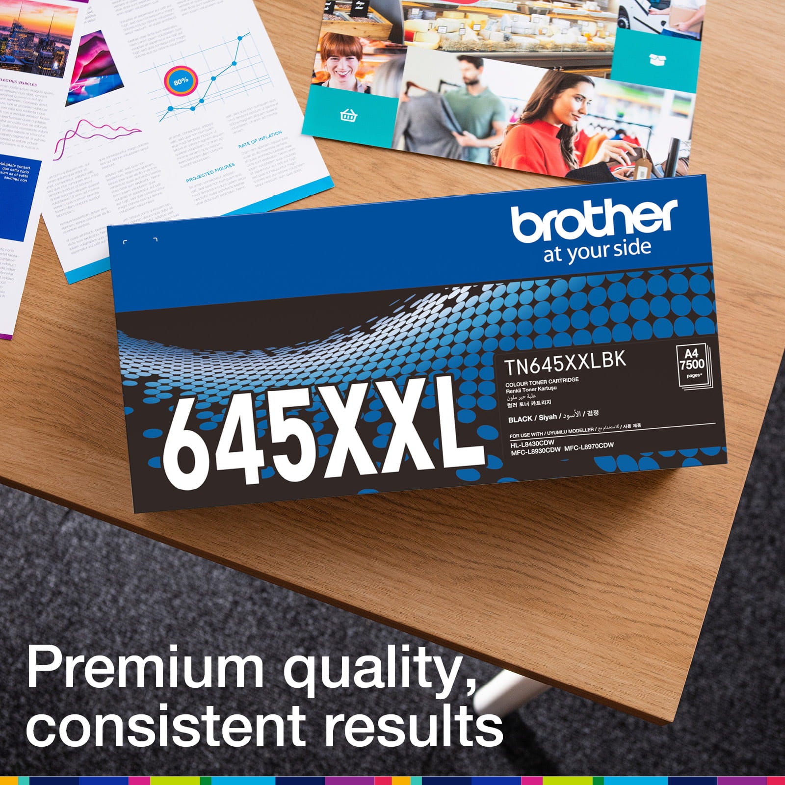 Brother TN-645XXLBK retail carton photographed beside printed colour documents