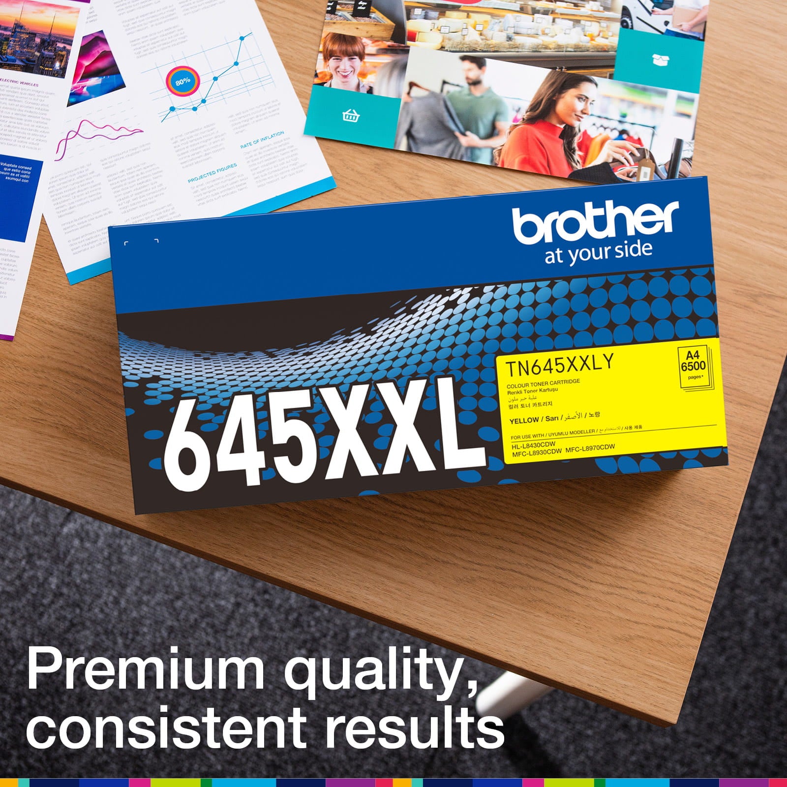 Brother TN-645XXLY retail carton photographed beside printed colour documents