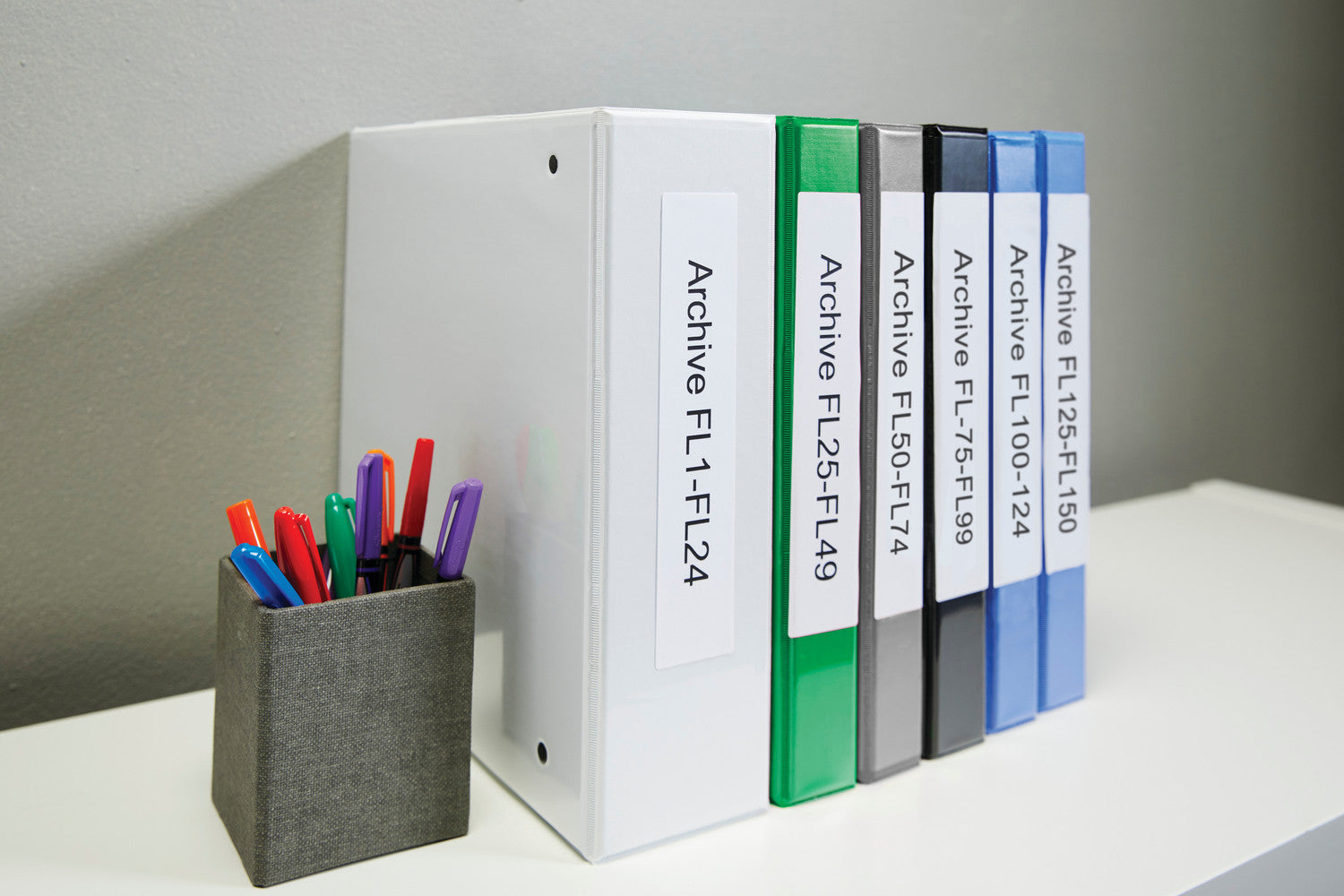 Set of white binders with labels on a gray surface