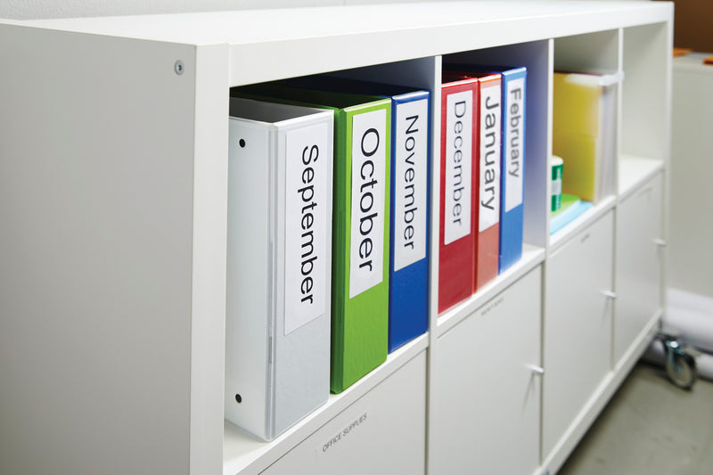 Colorful binders labeled from September to January in a white storage unit.