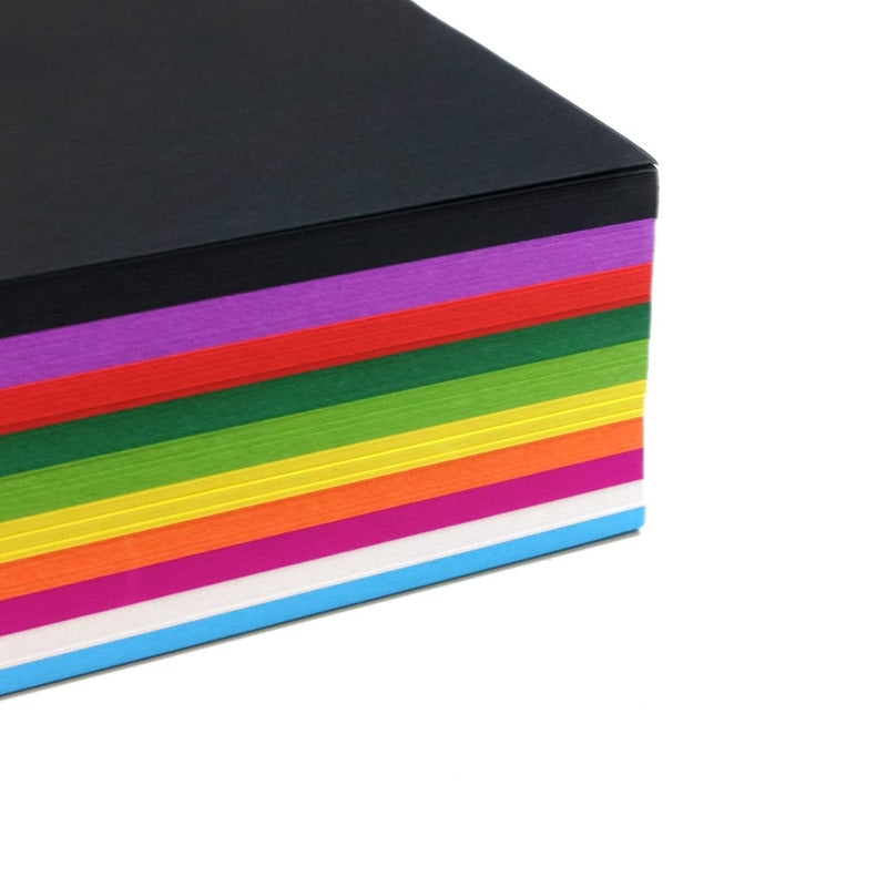 Corner view of a stack of Quill A4 assorted cover paper, black on top over purple, red, green, yellow, orange, pink, white and blue layers