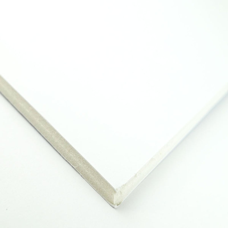 Corner of a Quill Foam Board A3 white showing the 5mm foam core edge between the white paper faces