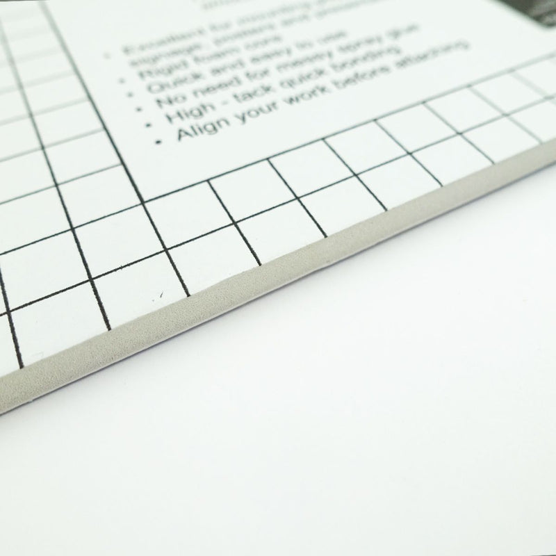 Close view of a Quill Self Adhesive Foam Board edge, showing the 5mm foam core under the gridded top sheet and printed instructions