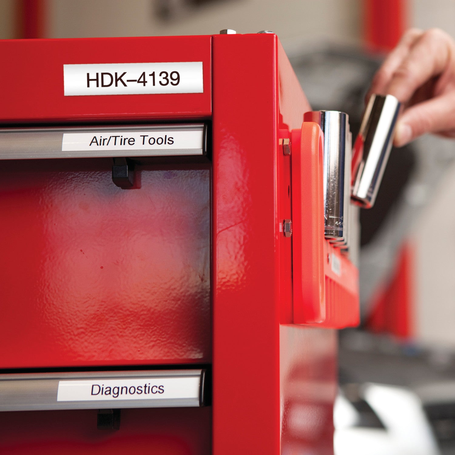 Red tool cabinet with labeled drawers in a workshop setting