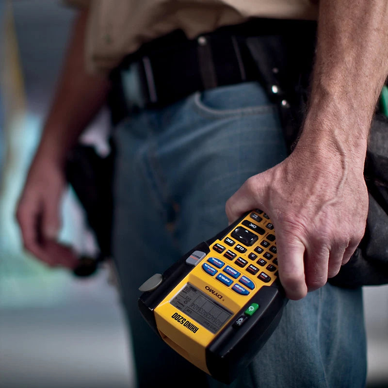 Person holding a yellow and black device with a blurred background