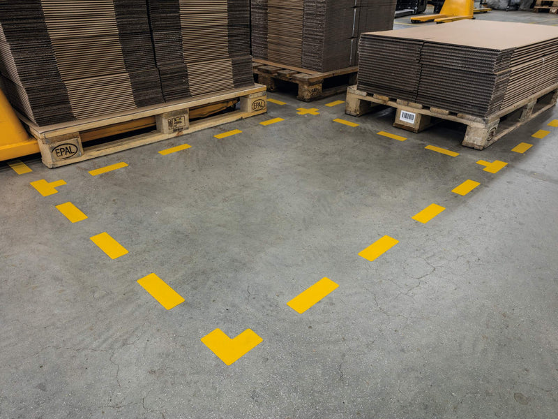 Dashed bay border of Durable yellow stripes and L shapes in front of pallets