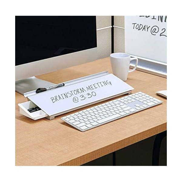 Desk scene with a glass pad that has a small drawer at one end, sitting between a white keyboard and a monitor with a note written on it; ACCO Australia do not list a drawer for QTGDP186