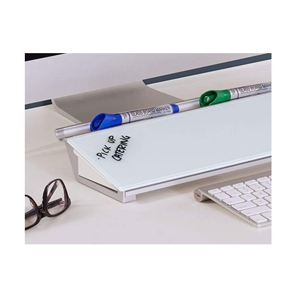 Glass computer pad on a desk with blue and green capped glass board markers on its top ledge, a handwritten note on the glass, a keyboard and a pair of glasses