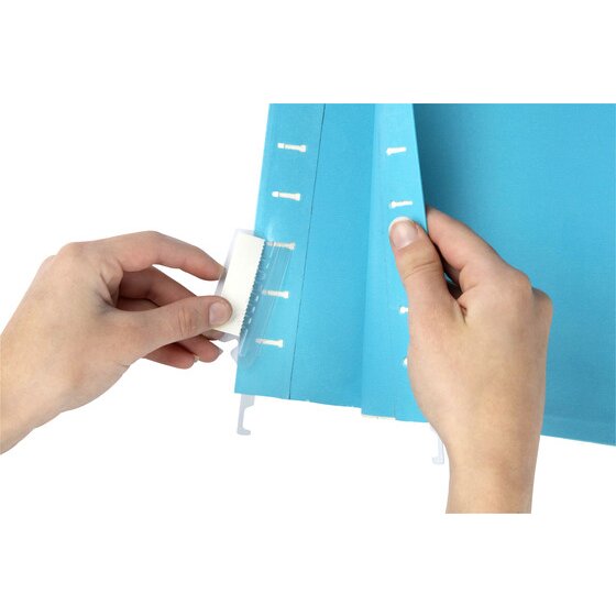 Hands pushing a clear Marbig tab into the slots along the top edge of a blue suspension file
