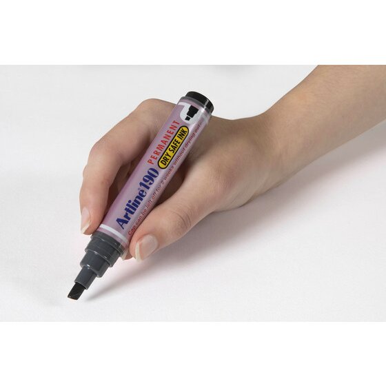 Hand writing with a black Artline 190 permanent marker, chisel nib on a pale grey surface