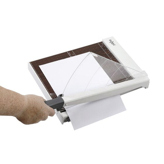 Hand lowering the arm of the Rexel ClassicCut 1210W to trim a sheet
